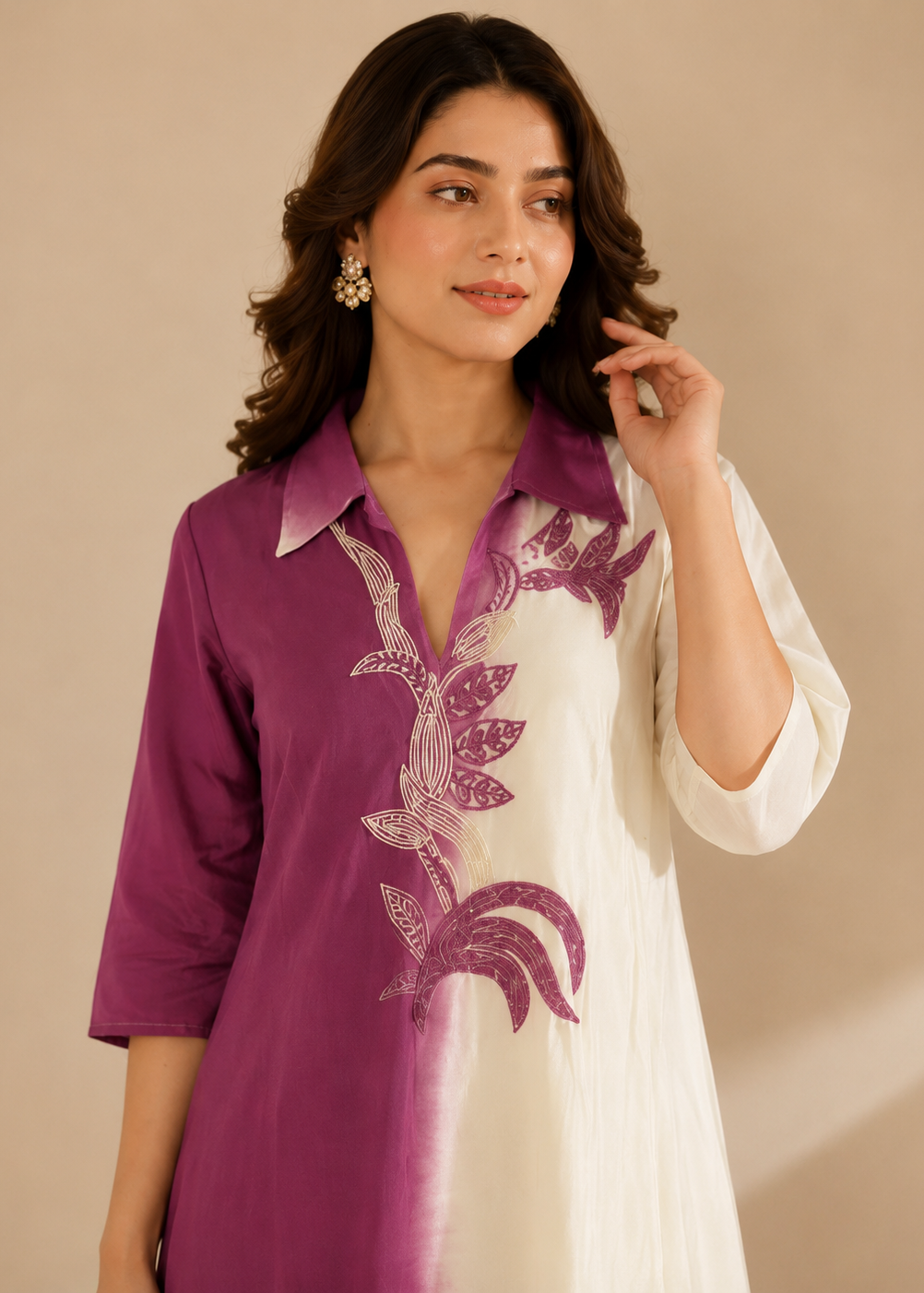 A woman modeling a purple and white printed kurta with a pointed collar and three-quarter sleeves, set against a solid beige background.