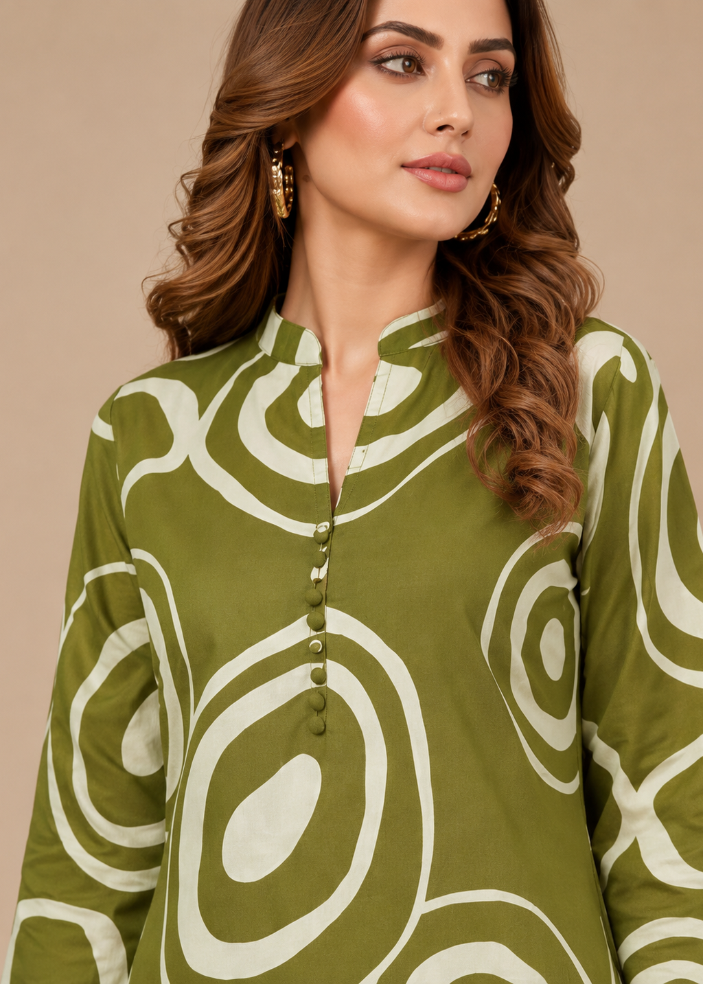 Woman wearing a green and white patterned top against a beige background