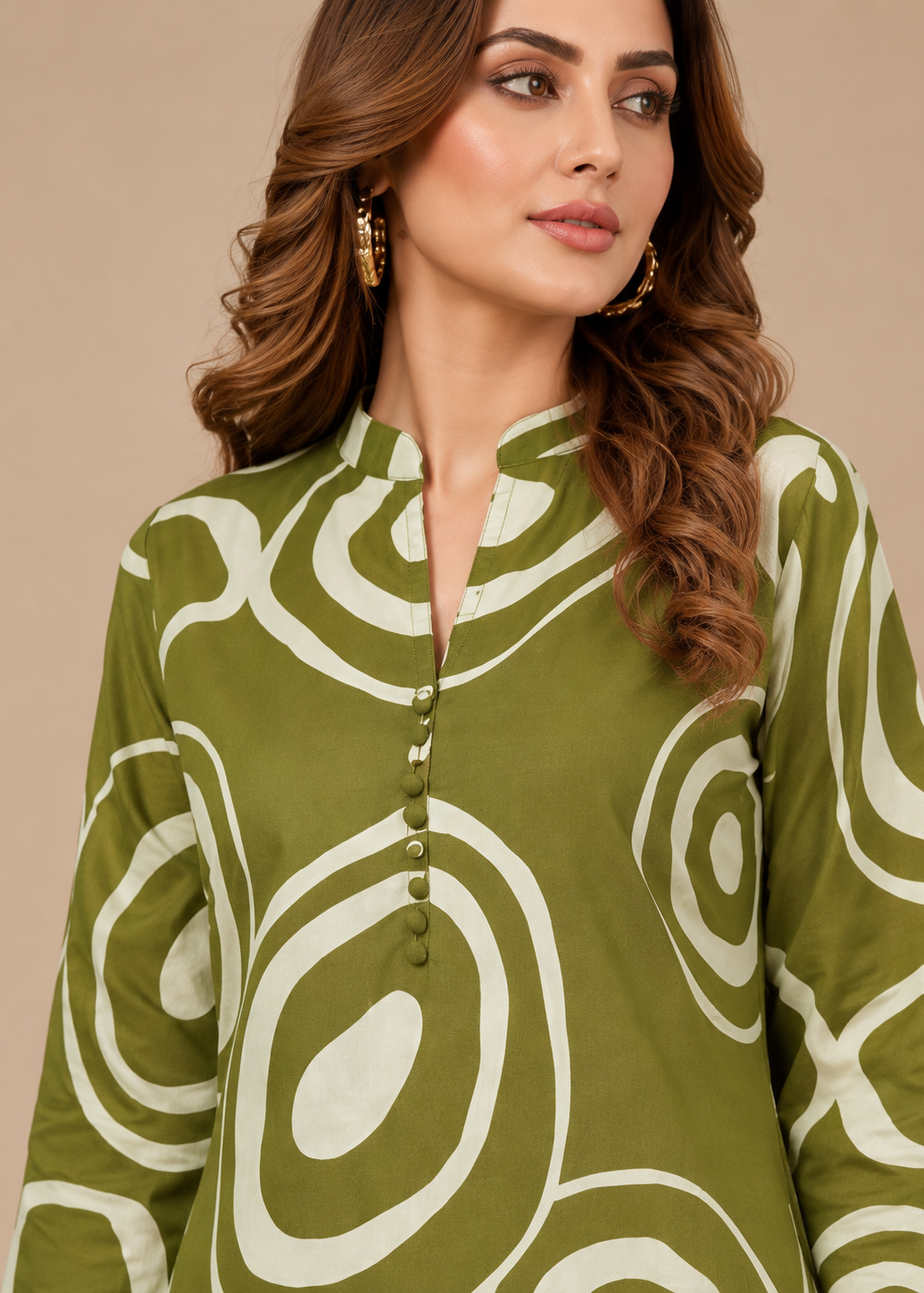 Woman wearing a green and white patterned top against a beige background