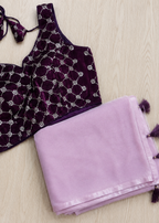 Purple velvet top with silver embellishments and a matching purple scarf on a light wooden surface.