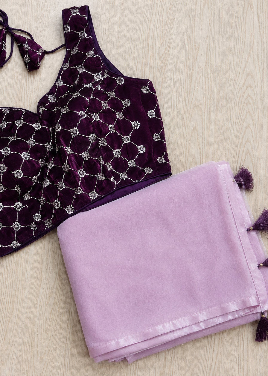 Purple velvet top with silver embellishments and a matching purple scarf on a light wooden surface.