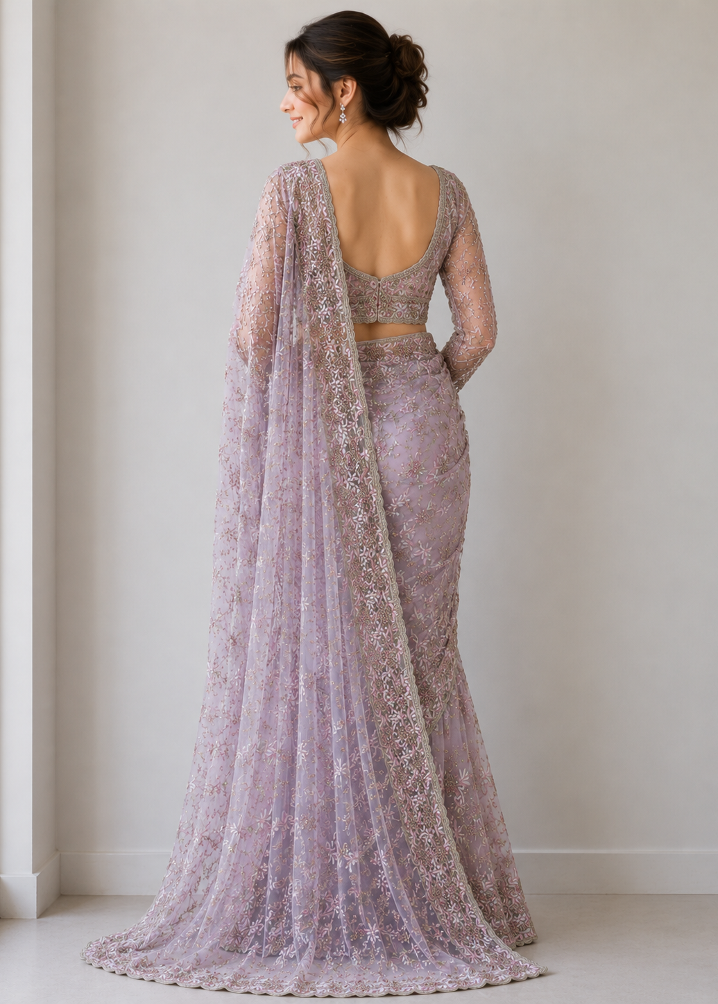 Woman wearing a purple lace saree with a plain background