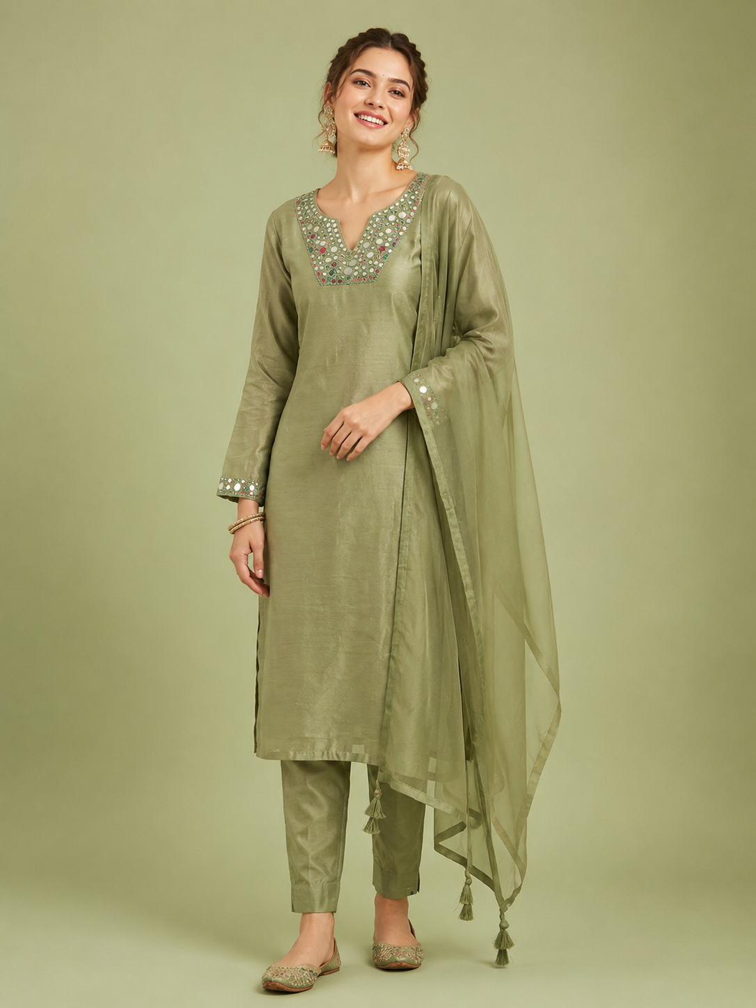 Woman wearing a green traditional outfit with a plain background