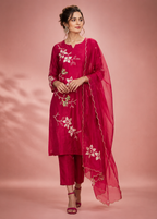 Woman wearing a pink embroidered outfit with a dupatta on a pink background