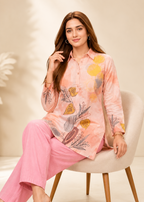 Woman wearing a pink floral outfit sitting on a chair with a beige background