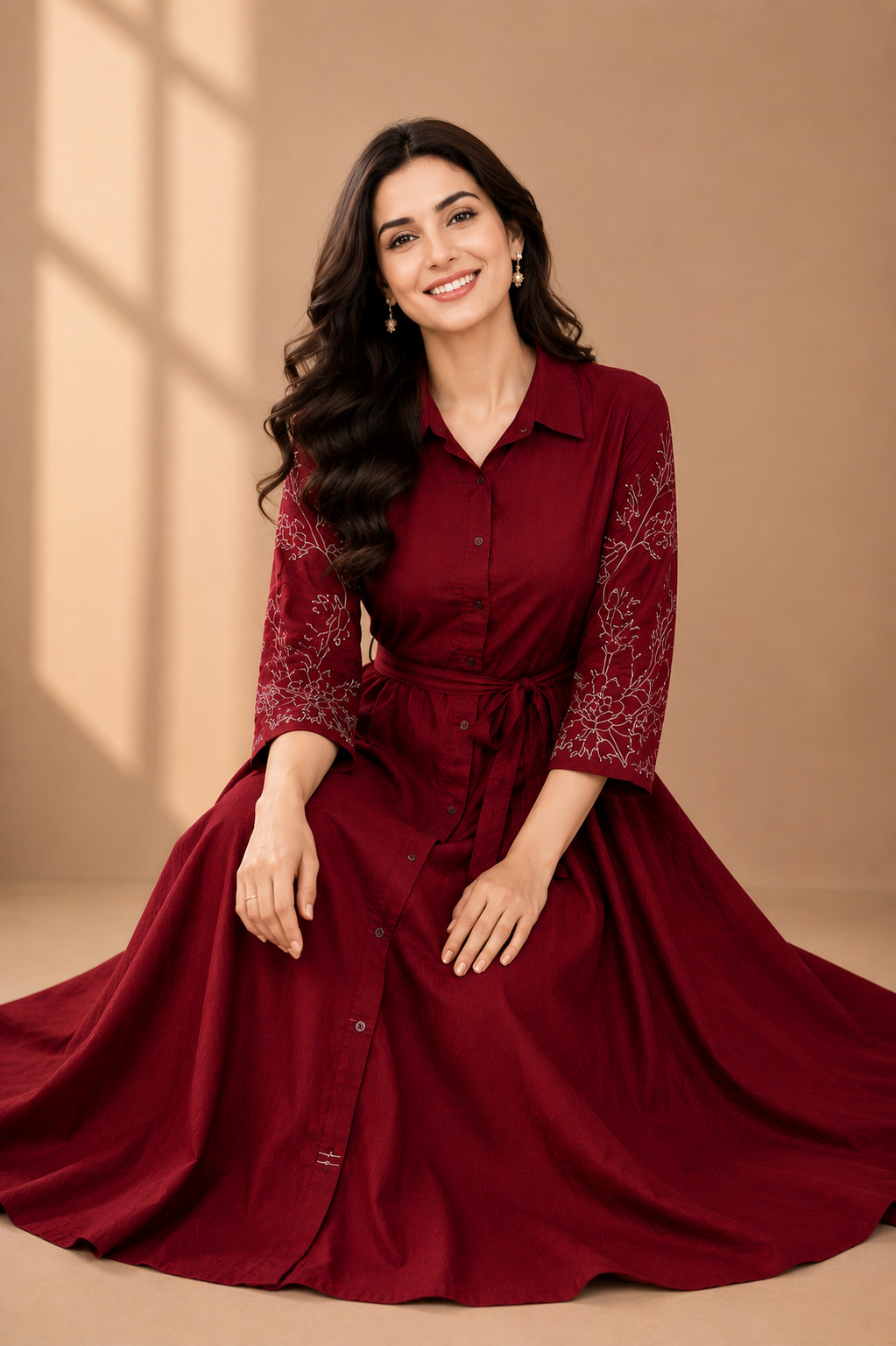 Woman wearing a burgundy dress with intricate lace details on a beige background