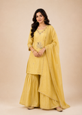 Woman wearing a yellow traditional outfit with a beige background