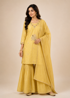 Woman wearing a yellow traditional outfit with a beige background