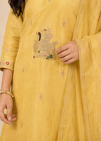 Yellow embroidered garment with intricate designs on a plain background