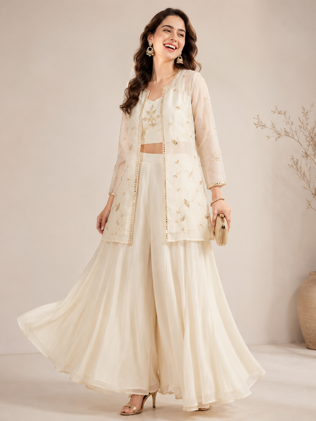 Woman wearing a cream-colored traditional outfit with a matching jacket against a neutral background