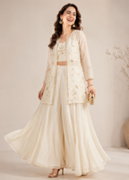 Woman wearing a cream-colored traditional outfit with a matching jacket against a neutral background