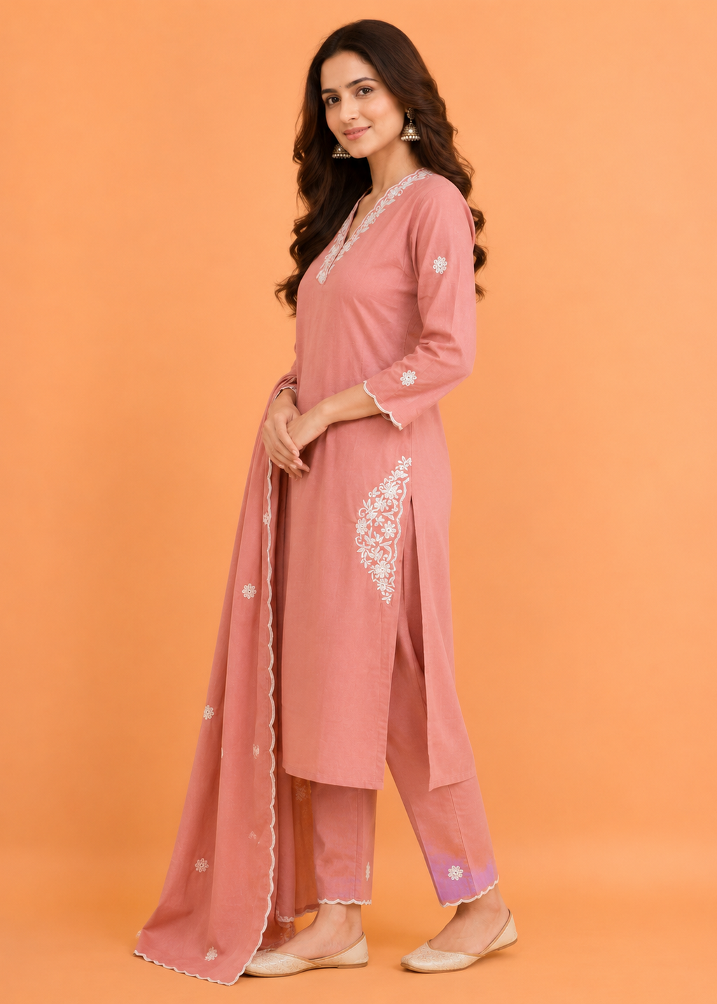Woman wearing a pink traditional outfit with embroidery on an orange background