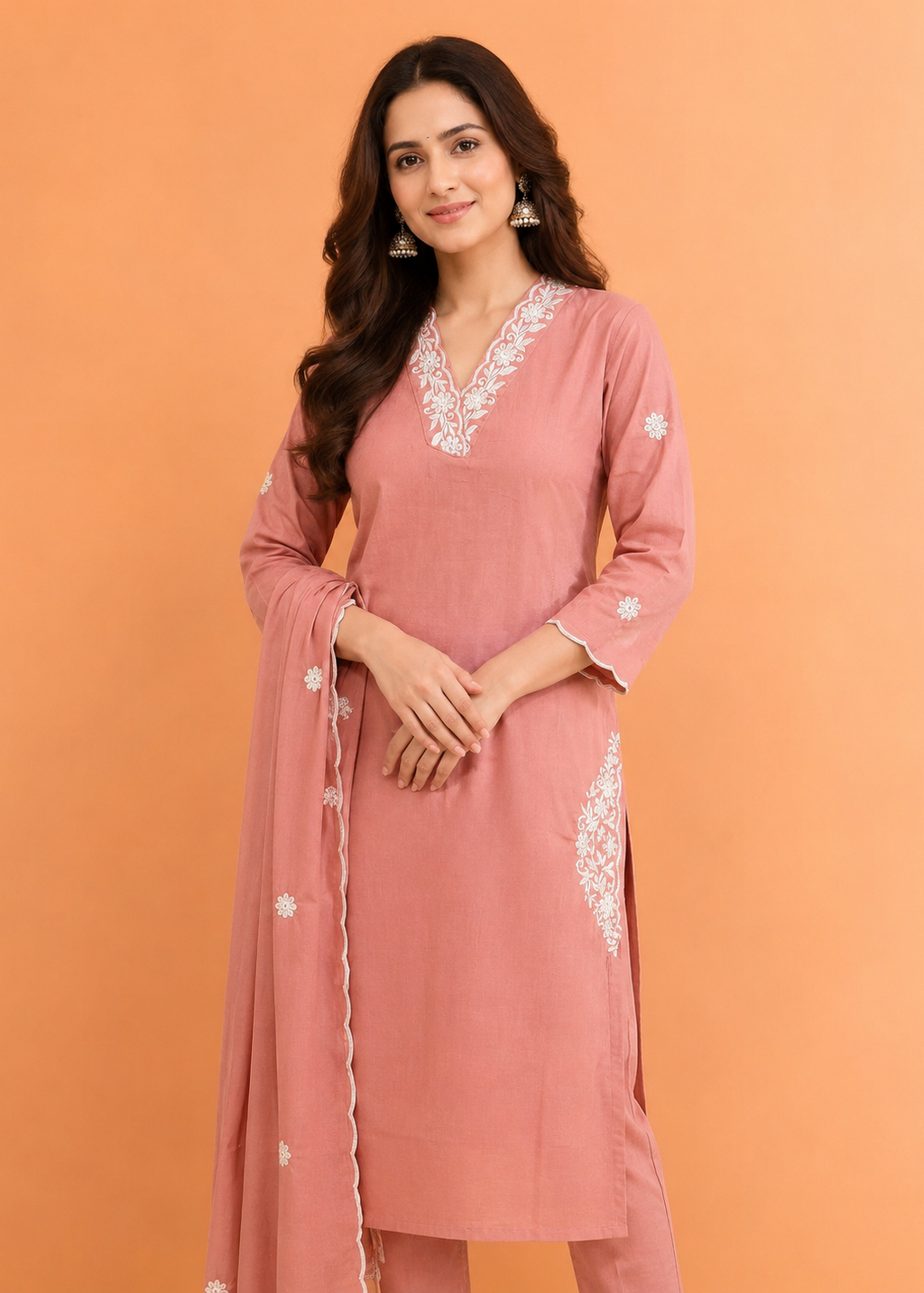 Woman wearing a pink embroidered outfit against an orange background