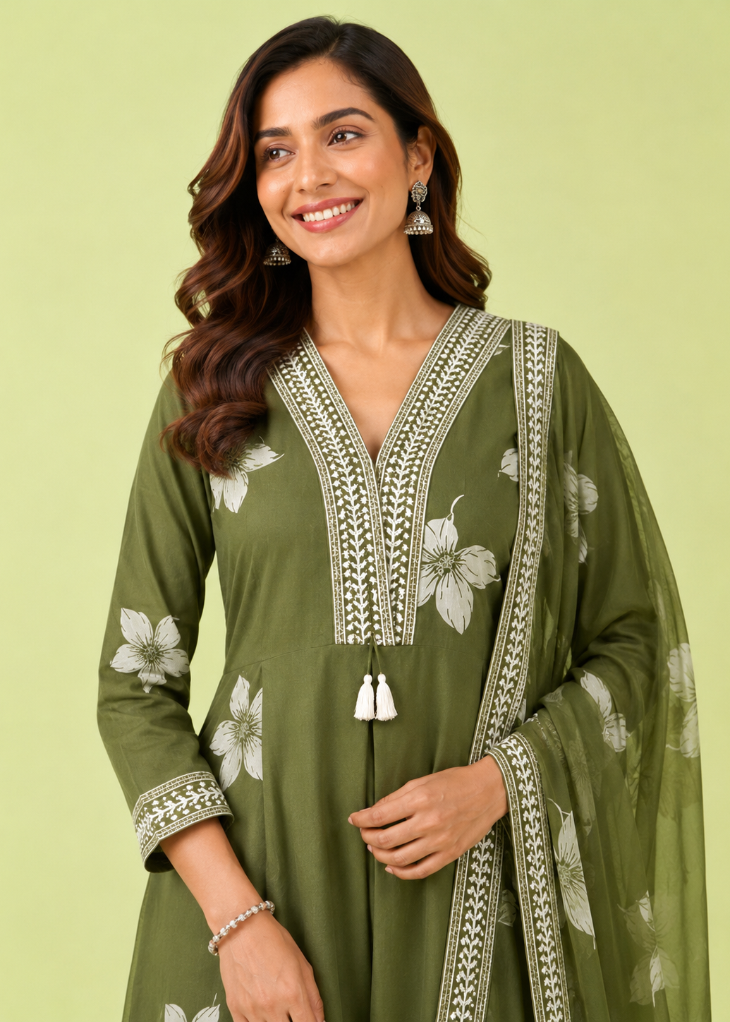 Woman wearing a green embroidered dress against a light green background