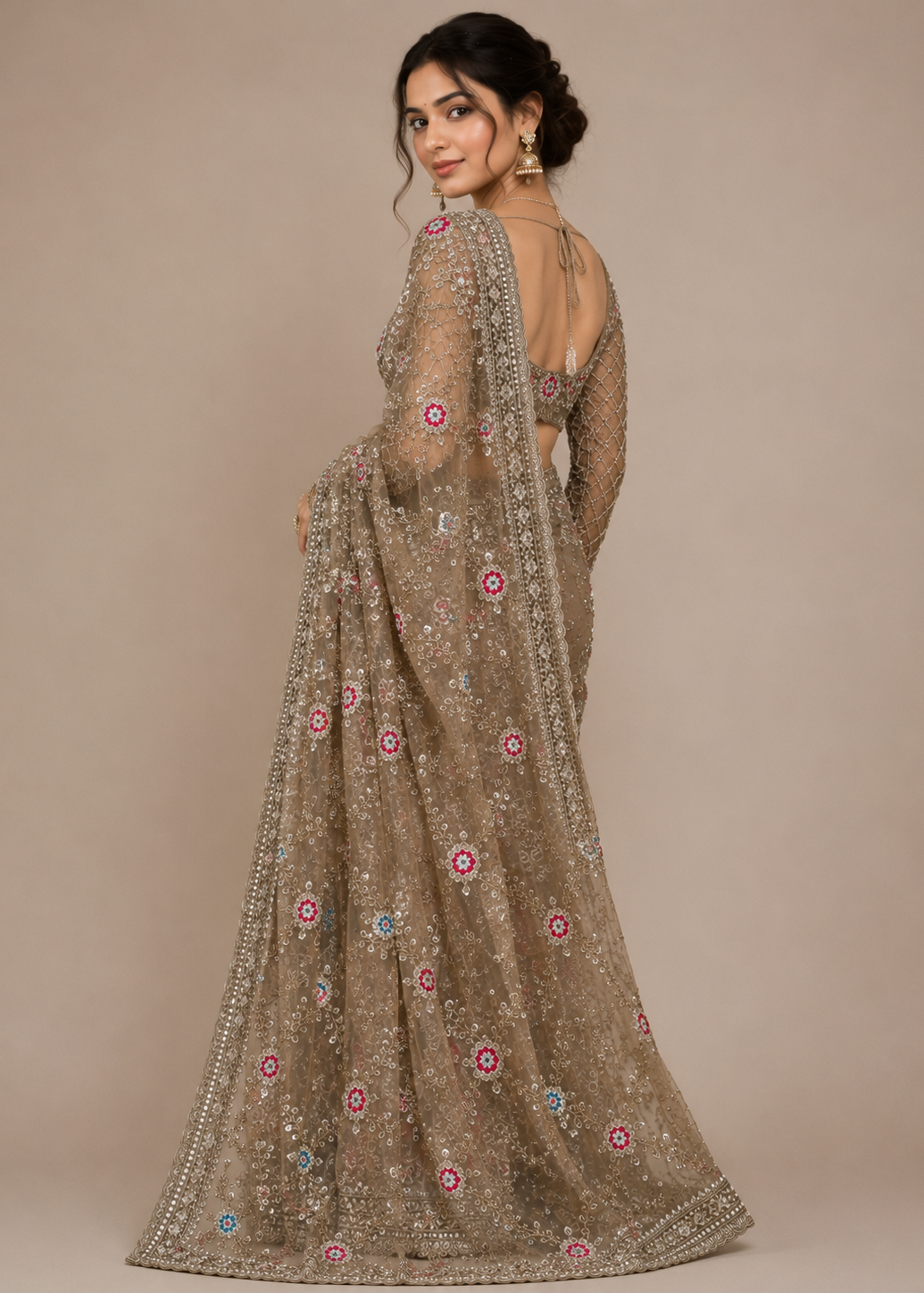 Woman wearing a brown embroidered saree with a plain background
