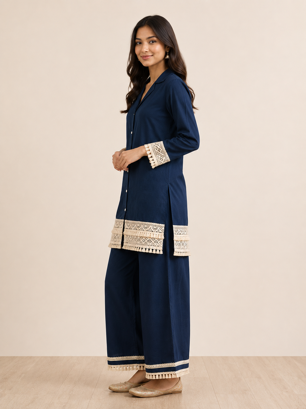 Woman wearing a navy blue outfit with gold embroidery on a beige background