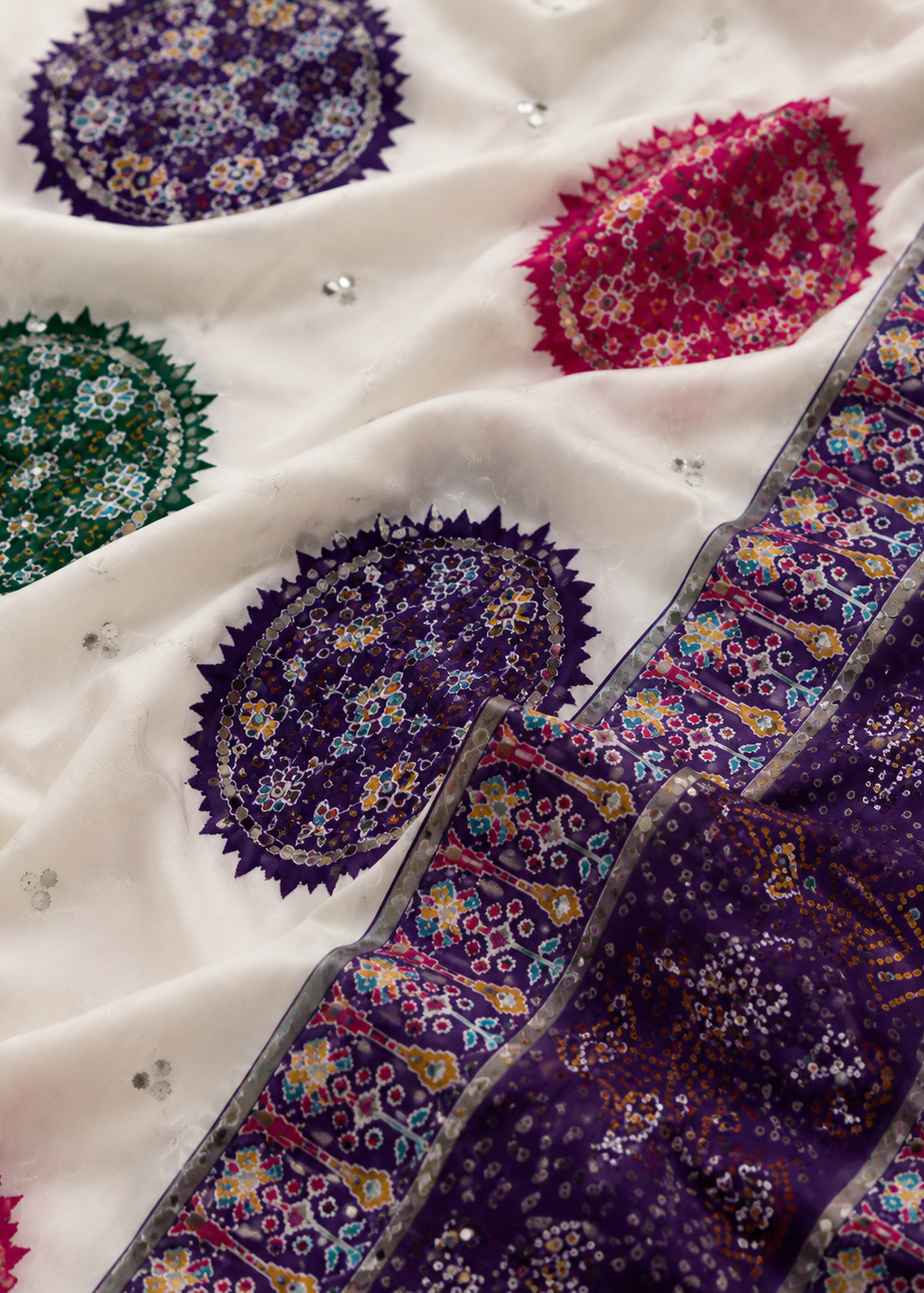 Close-up of a fabric with colorful paisley patterns on a white background