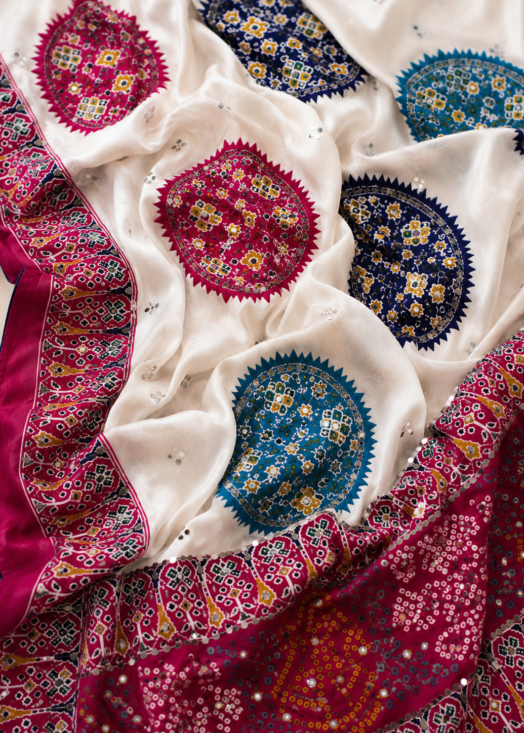 Colorful fabric with intricate patterns in red, blue, and white.