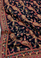 Close-up of a patterned fabric with paisley designs on a dark background