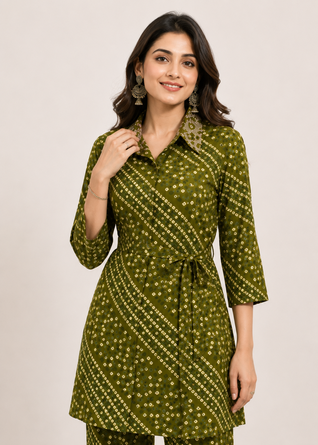 A woman modeling a green kurta with a white geometric print, paired with matching green pants, against a plain light beige background.