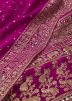 Close-up of a purple fabric with gold embroidery and embellishments