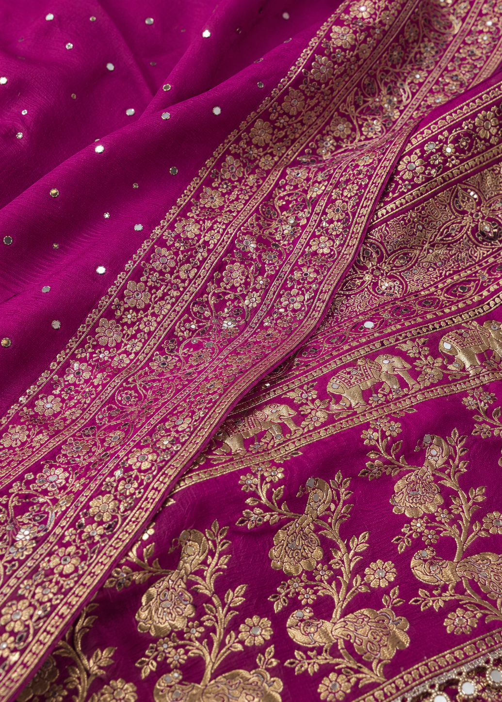 Close-up of a purple fabric with gold embroidery and embellishments