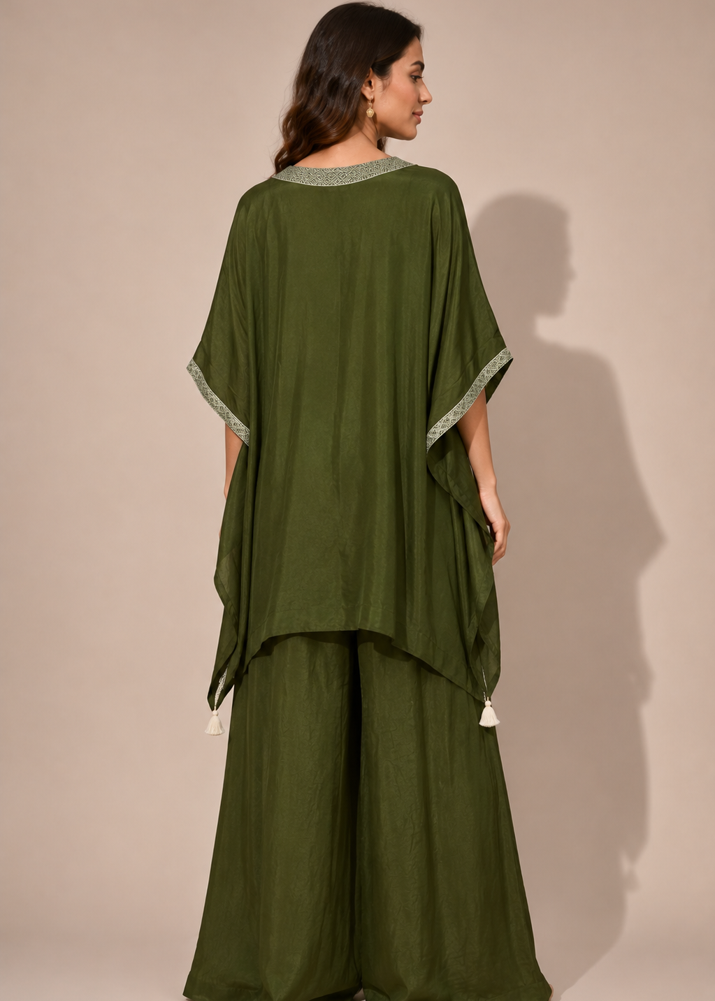 A woman modeling an olive green two-piece kurta set, shown from the back against a solid beige studio background.