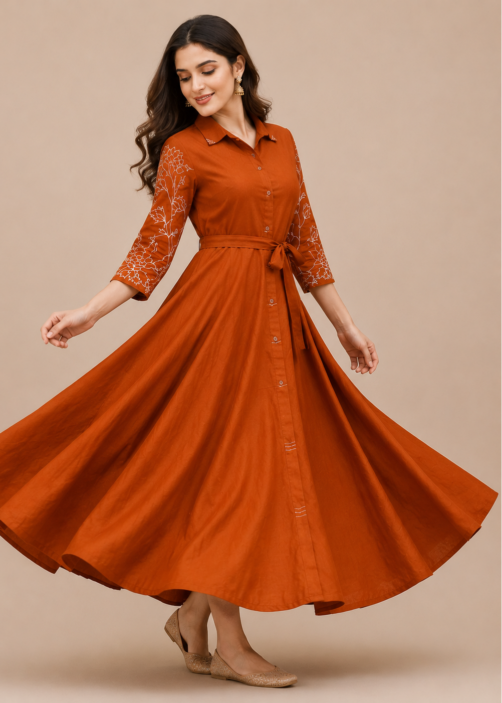 A woman modeling a rust-orange midi dress with lace three-quarter sleeves and a matching waist tie, captured mid-spin against a solid beige studio background.